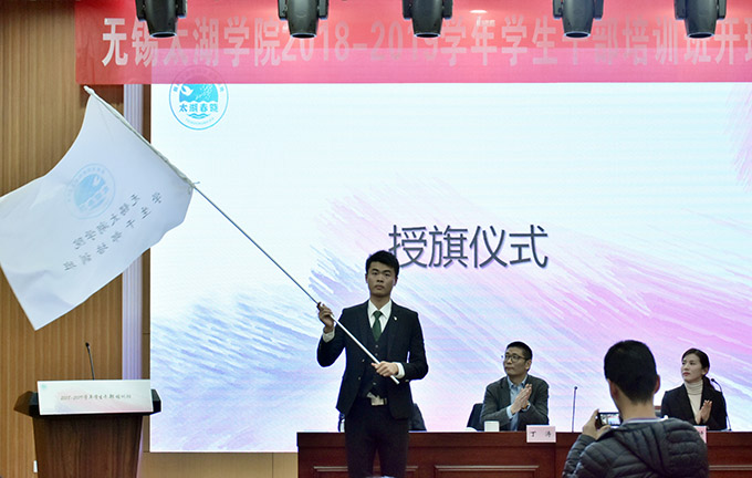 培训班负责人陈妍妍向大学生班干部培训班的成员代表进行授旗.jpg